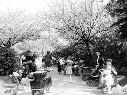 People enjoy the mild temperatures of the 1947 spring on the Champ de Mars near the Eiffel