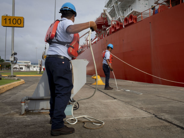GettyImages-1228112640 Crew members moor the La Mancha Knutsen LNG tanker at a port on the Panama Canal in Panama