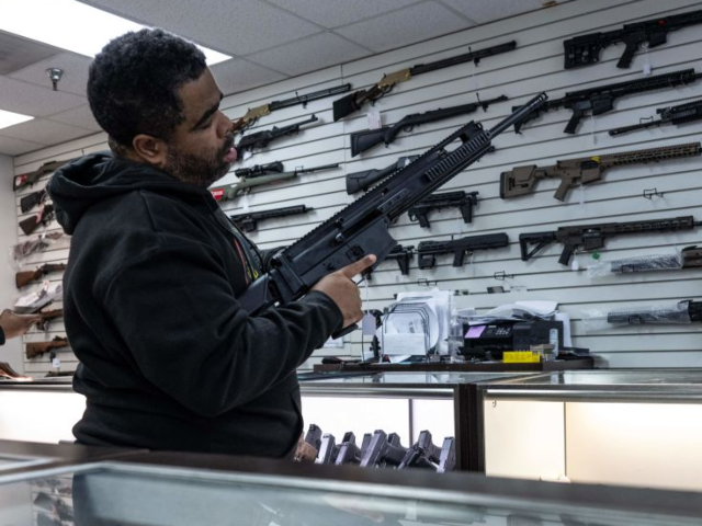 A customer looks at a gun in EJB's Gun Shop in Capitol Heights, Maryland on March 14, 2023