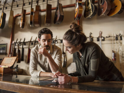 Young couple working behind counter in music store