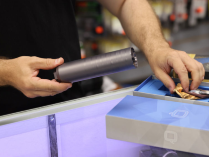 DELRAY BEACH, FLORIDA - MARCH 24: Ian Brabender helps a customer buying a gun suppressor a