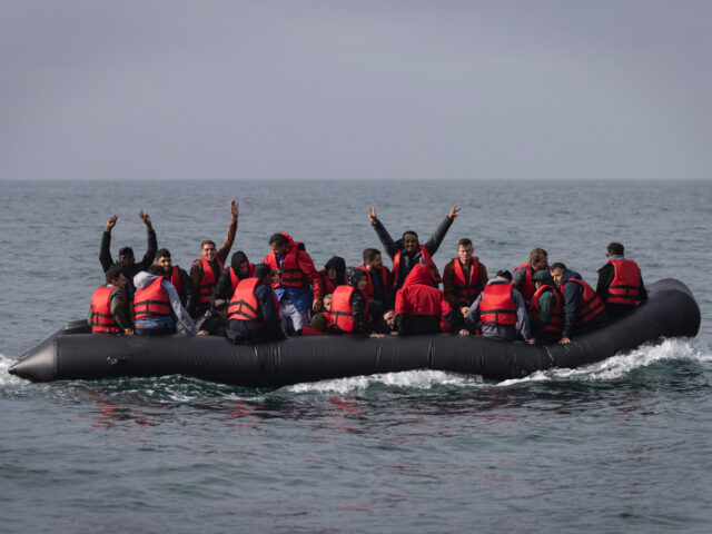 AT SEA, ENGLAND - AUGUST 04: An inflatable craft carrying migrants crosses the shipping la