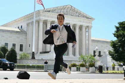 TOPSHOT-US-VOTE-JUSTICE-TRUMP-IMMUNITY TOPSHOT - A journalist runs across the US Supreme Court plaza carrying an opinion to a new