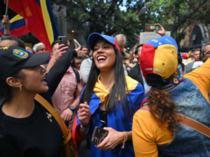 A woman wearing a Venezuelan flag smiles during a protest called by the opposition on the