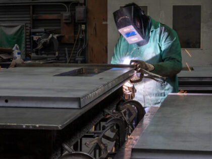 A worker arc welds a metal door during production at the Metal Manufacturing Co. facility