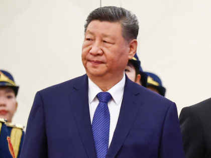 China's President Xi Jinping (L) stands next to France's President Emmanuel Macron during