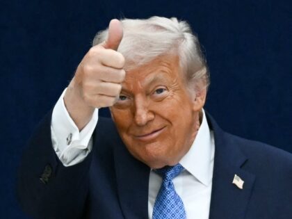 US President Donald Trump gives a thumbs up as he departs the stage during the signing cer