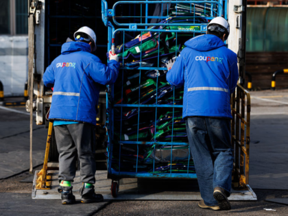 Employees load Coupang Inc. reusable bags for fresh food into a delivery truck at one of t