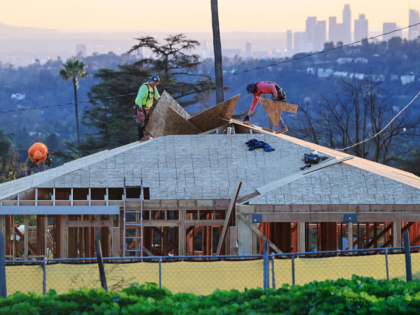 ALTADENA, CALIFORNIA - DECEMBER 29: Workers help rebuild a home on a property which was de