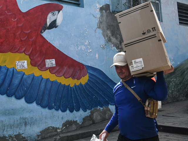CARACAS, VENEZUELA - JANUARY 4: A man carries boxes with supplies in Petare a day after th