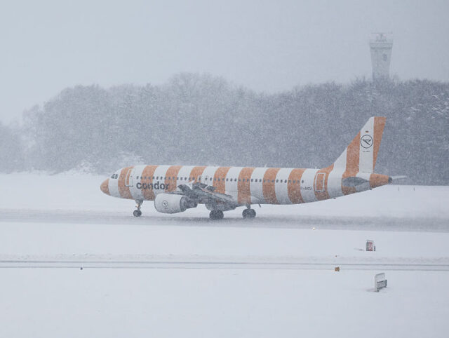 08 January 2026, Hamburg: A Condor plane taxis over the snow-covered runway at Hamburg Air
