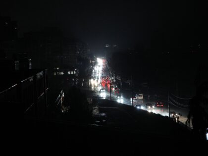 Cars move along Sicheslavska Naberezhna Street in the evening during a blackout in Dnipro,