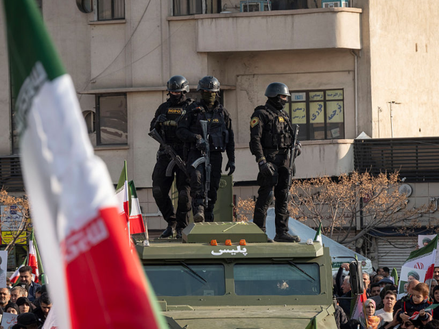 GettyImages-2255674943 Armed members of Iran's police special forces monitor an area while standing on an armored