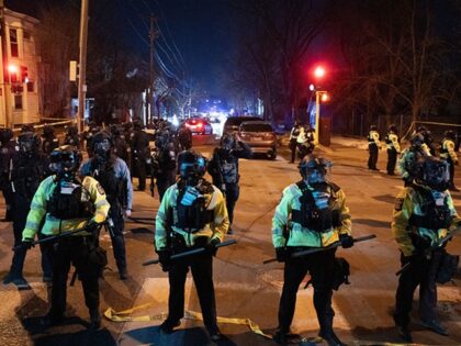 Minnesota State Troopers hold back a crowd after Federal law enforcement officers confront