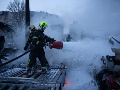 Ukrainian emmergency personnel work to extinguish a fire at the site of an air attack in K