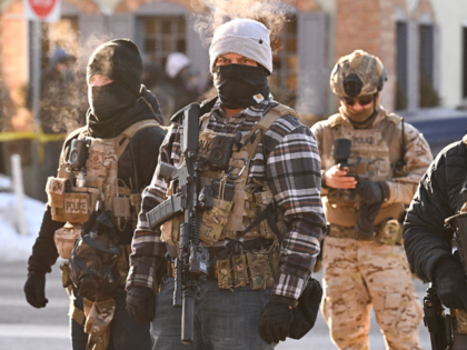 GettyImages-2257421455 Federal agents look on as demonstators gather near the site of where state and local autho