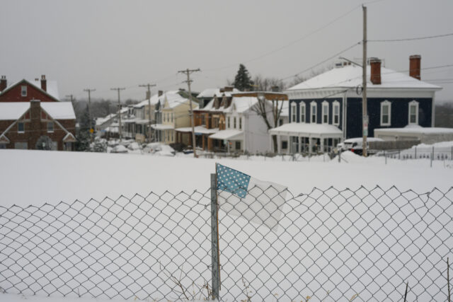 A US flag on a fence during a winter storm in Pittsburgh, Pennsylvania, US, on Monday, Jan