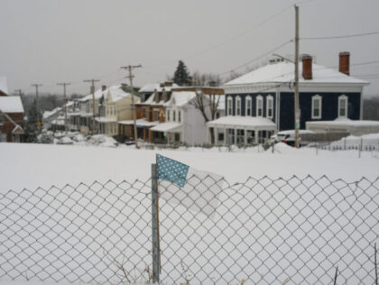 A US flag on a fence during a winter storm in Pittsburgh, Pennsylvania, US, on Monday, Jan