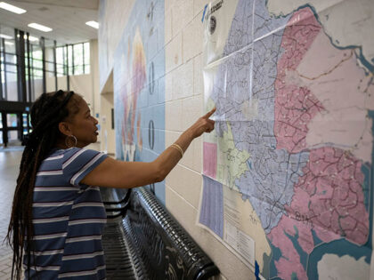 Yolanda Hutcherson surveys Northern Virginia's congressional map at a voting precinct at C