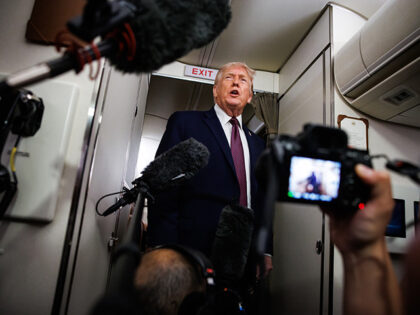 U.S. President Donald Trump takes questions from the members of the press aboard Air Force