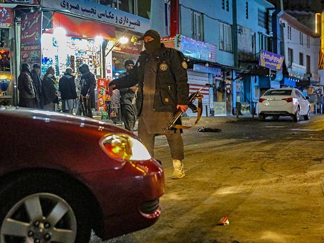 Taliban security personnel stand guard at a blast site following an explosion in the Shahr