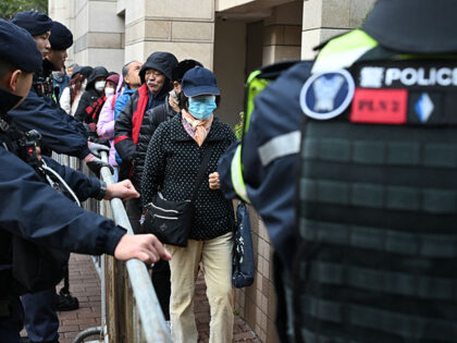 Visitors pass by police as they enter the West Kowloon Magistrates' court in Hong Kong on