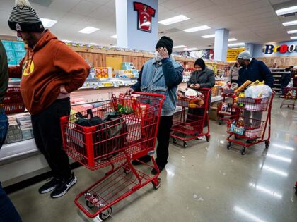 Shoppers stand in line to check out at a grocery store on January 23, 2026 in Washington,