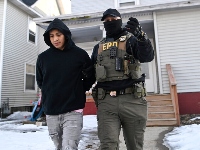 An ICE Enforcement and Removal Operations agent detains a person from a house on January 1