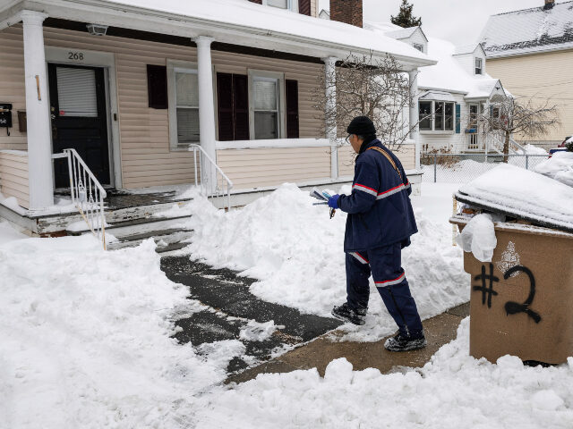 A U.S. Postal Service carrier delivers mail on January 26, 2026 in Stamford, Connecticut.