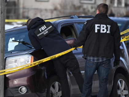 Law enforcement officers attend to the scene of the shooting involving federal law enforce