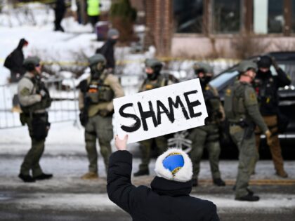 MINNEAPOLIS, MINNESOTA - JANUARY 07: An onlooker holds a sign that reads "Shame" as member