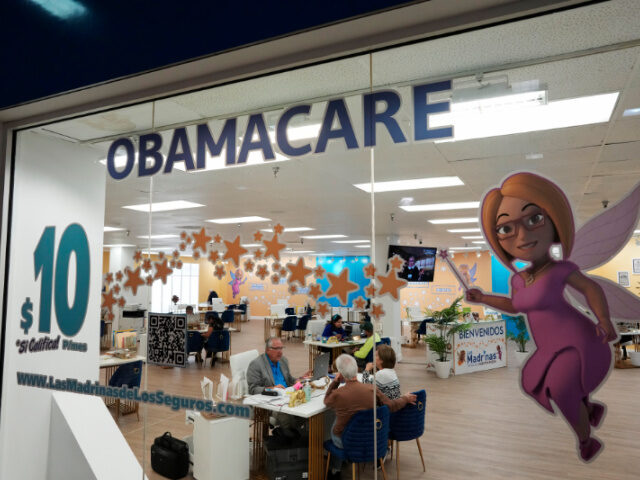 Obamacare Signage An insurance agent talks with clients inside the main location of Las Madrinas de los Segu