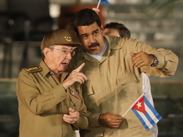 Cuban President Raul Castro speaks with Venezuela's President Nicolas Maduro during a