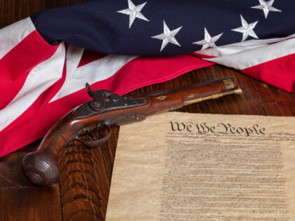 Antique pistol with thirteen star flag and the constitution of the United States on dark w