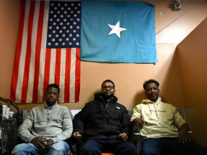 Somali Residents in Minneapolis Patrons watch a soccer game as they sit under an American and Somali flag at a cafe inside