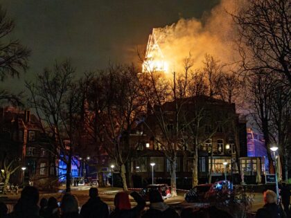 People look at the tower of the Vondelkerk church on fire during New Year's Eve, in Amster