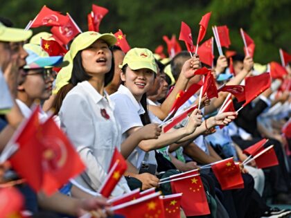 ectators wave flags during a grand gathering to commemorate the 80th anniversary of the vi