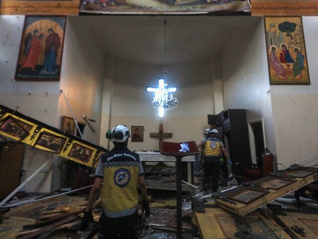 TOPSHOT - Rescuers inspect the damage at the site of a reported suicide attack at the Sain