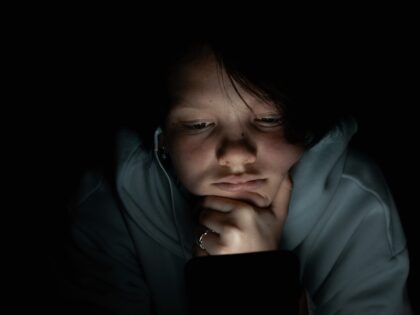 depressed teen talking to AI chatbot in the dark