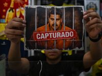 A man shows an image featuring a digitally altered image of the ousted Venezuelan Presiden