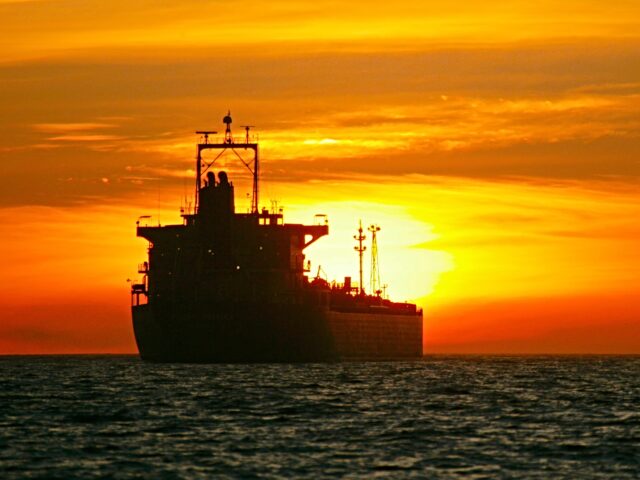 An oil tanker sits at anchor during sunset outside the Port of Long Beach.