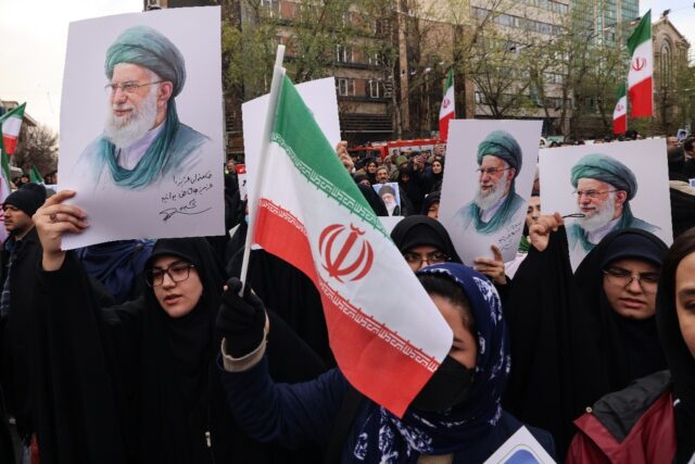 Iranian women hold portraits of Iran’s Supreme Leader Ayatollah Ali Khamenei during the