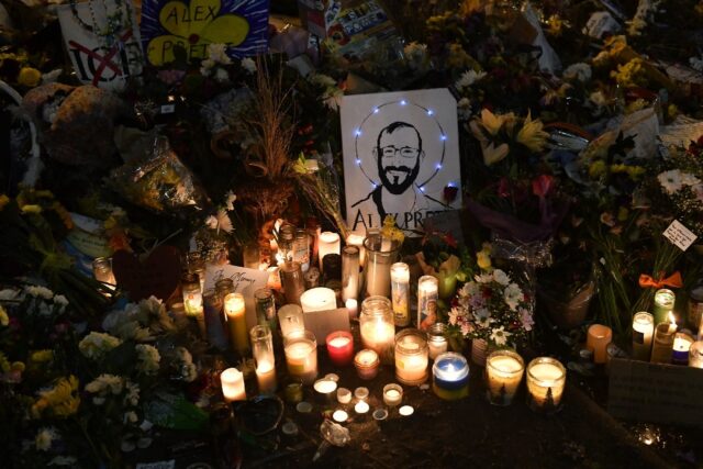 A drawing of Alex Pretti is displayed alongside candles at a makeshift memorial in Minneap