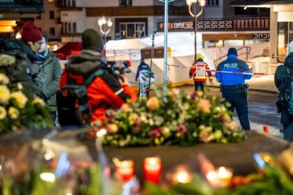 Flowers left at the scene of a fire that killed dozens in a Swiss ski resport