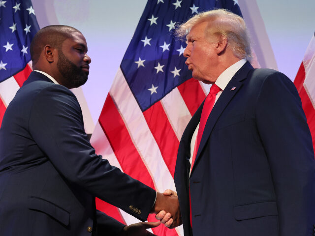 Rep. Byron Donalds (R-FL) shakes hands with former U.S. President Donald Trump during the