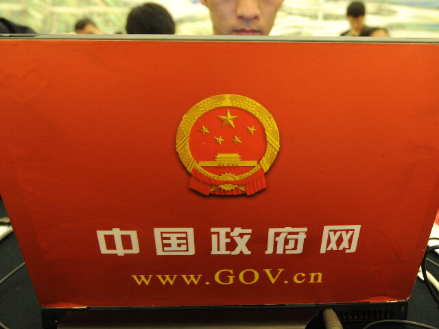 A journalist works with a government's official computer during a press conference fo