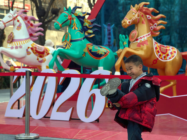 A child poses for photos near decorations set up ahead of the Chinese Lunar New Year of th