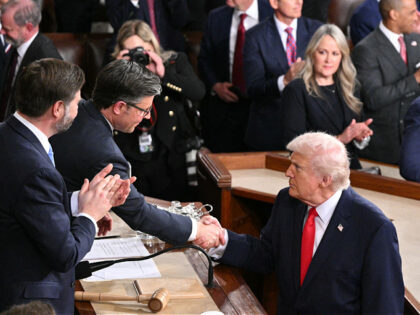 US President Donald Trump shakes hands with US Speaker of the House Mike Johnson as he con