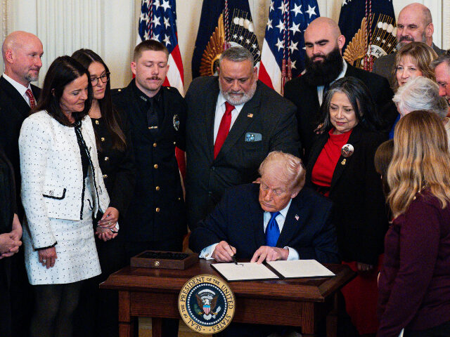 US President Donald Trump, center, signs a proclamation dedicating February 22 as Angel Fa