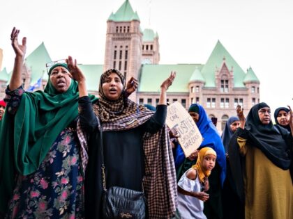 Supporters Sirad Ahmed, left, and Ifrah Mubarak pray at the end of the rally for former Mi